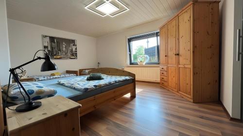 a bedroom with a bed and a desk and a window at Fewo Carpe Diem in Scheuerfeld