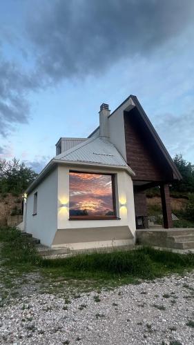 a house with a window with a sunset in it at Villa Luce in Kolašin