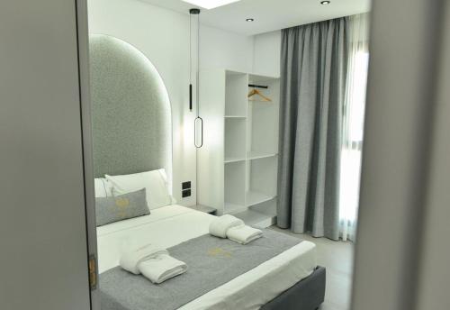a bedroom with a bed and a large mirror at Grand Avelor Hotel in Vlorë