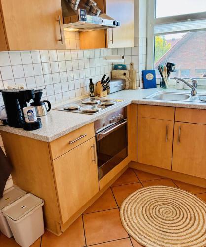 a kitchen with a sink and a stove top oven at Ferienwohnung DE VRIESenkoje in Südbrookmerland