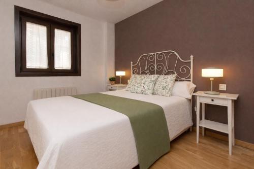 a bedroom with a large white bed and a window at Casa MiMar by BeValle in Panticosa