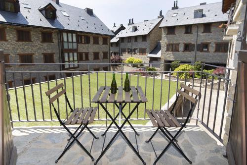 a table with two wine bottles on it on a balcony at Refugio del Roble by BeValle in Panticosa