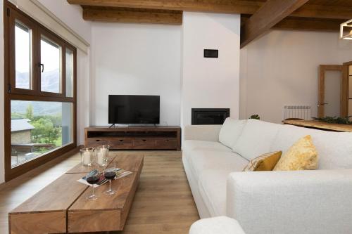 a living room with a white couch and a wooden coffee table at Sueños del Garmo by BeValle in Panticosa