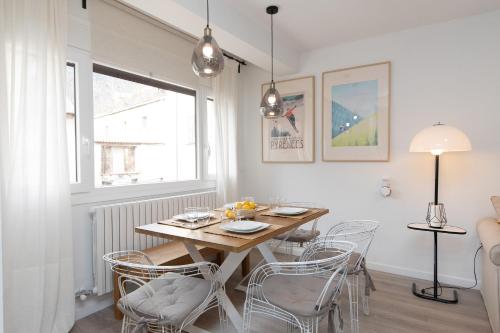 a dining room with a wooden table and chairs at Sky Biescas I by BeValle in Biescas
