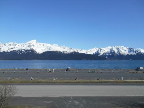 een grote hoeveelheid water met sneeuw bedekte bergen op de achtergrond bij Alaska's Point of View in Seward