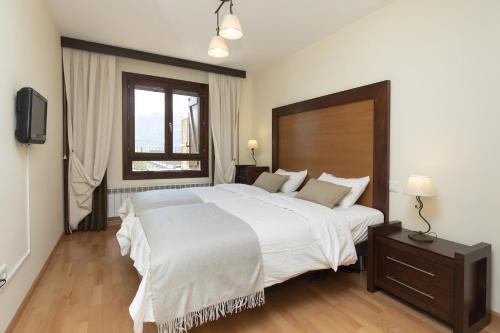 ein Schlafzimmer mit einem großen weißen Bett und einem Fenster in der Unterkunft Refugio del Valle by BeValle in Panticosa