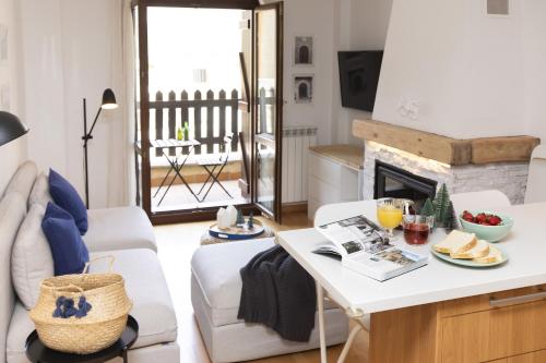 a living room with a table and a fireplace at PanticAsa Azul by BeValle in Panticosa