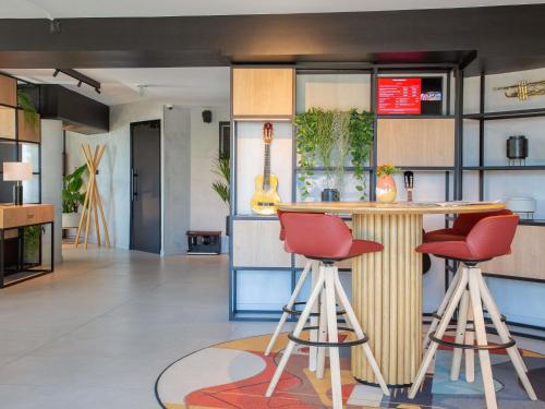 a kitchen with a bar and two red stools at ibis Nice Aéroport Promenade des Anglais in Nice