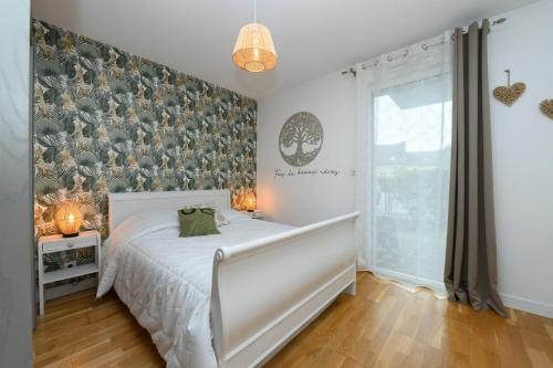 a bedroom with a bed and a large window at Laïta - Séjour à Quimperlé in Quimperlé