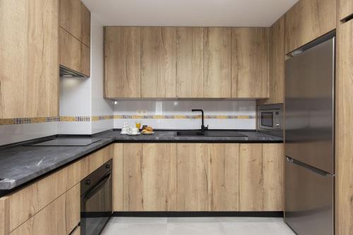 a kitchen with wooden cabinets and a sink at Casa Lite by BeValle in Escarrilla