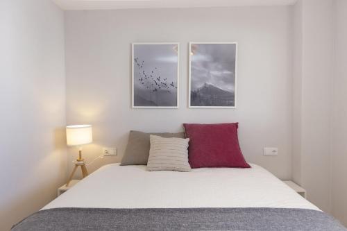 a bedroom with a bed with two pictures on the wall at La Ventana de Formigal by BeValle in Formigal