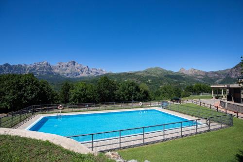 a large swimming pool with mountains in the background at CuMbre del Sarrio by BeValle in Panticosa