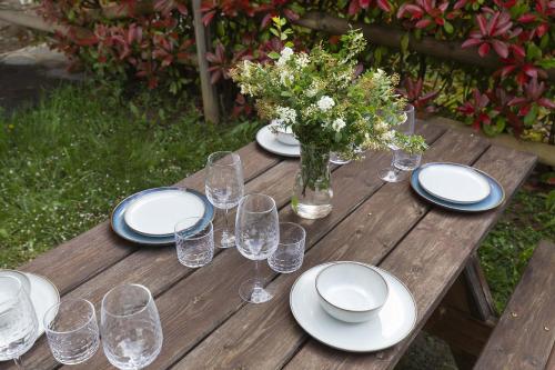 a wooden table with plates and glasses and a vase of flowers at Casa Vity by BeValle in Panticosa