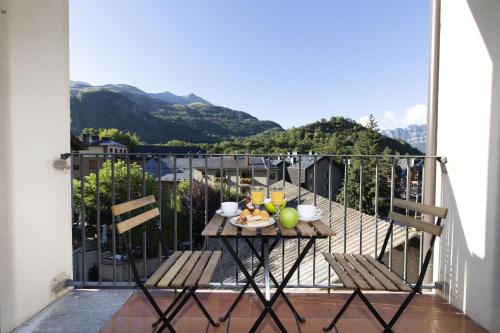 a table with food on a balcony with mountains at Casa Josephine by BeValle in Panticosa