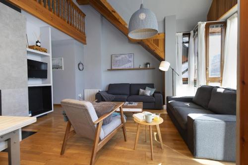 a living room with a couch and a table at Ático de Pao by BeValle in Panticosa