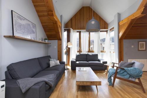 a living room with a couch and a table at Ático de Pao by BeValle in Panticosa