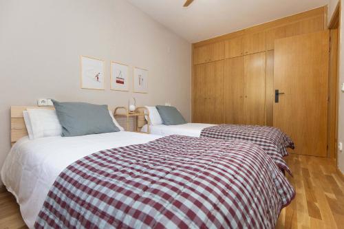 a bedroom with two beds and wooden cabinets at Balaitus by BeValle in Escarrilla