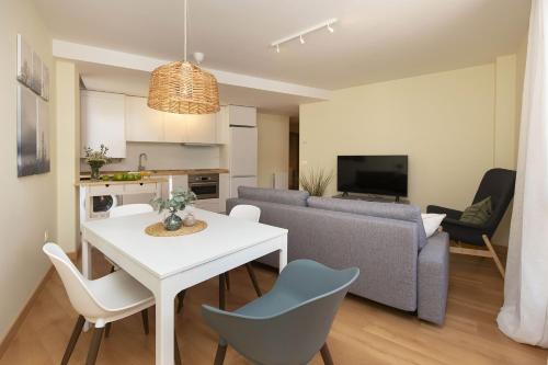 a living room with a couch and a table and chairs at TenaNatura Ski by BeValle in Escarrilla
