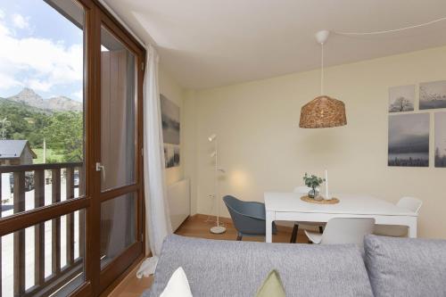 a living room with a table and a balcony at TenaNatura Ski by BeValle in Escarrilla