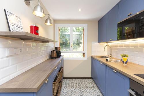 a kitchen with blue cabinets and a sink at Montibel by BeValle in Panticosa