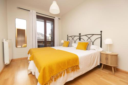 a bedroom with a large bed with a yellow blanket at Senda by BeValle in Panticosa