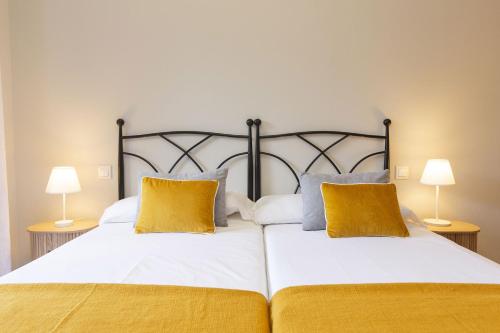 a bedroom with two beds with yellow pillows at Senda by BeValle in Panticosa