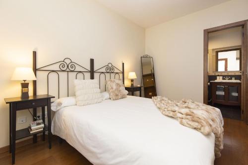 a bedroom with a white bed with a blanket on it at Pirenaica by BeValle in Escarrilla