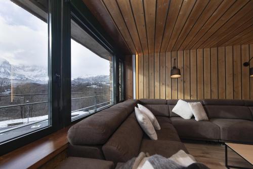 a living room with a couch and a large window at Casa BellaVista by BeValle in Panticosa