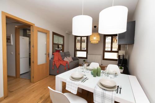 a kitchen and living room with a white table and chairs at Casa de La Laguna by BeValle in Panticosa