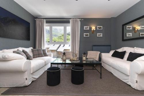 a living room with two white couches and a table at El Ciervo de Santa María by BeValle in Panticosa