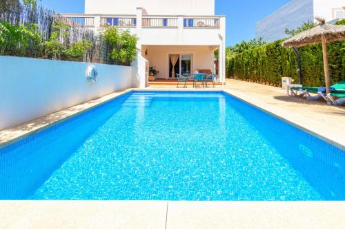 a swimming pool in front of a house at Villa Lagoa in Cala Dor in Cacla D'or
