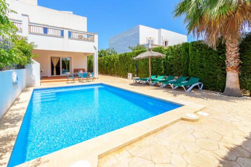 a swimming pool in the backyard of a house at Villa Lagoa in Cala Dor in Cacla D'or