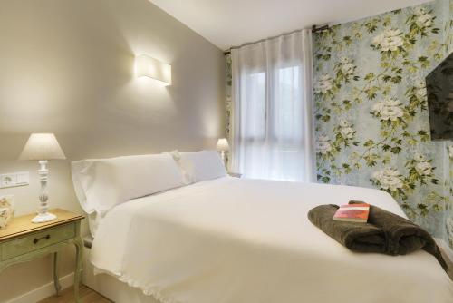 a bedroom with a white bed and a window at El Rincón del Verde by BeValle in Panticosa