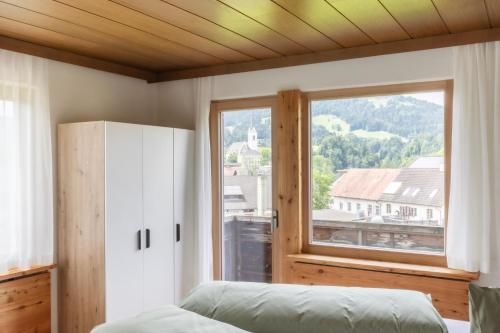 a bedroom with a bed and a large window at Egg'spresso Gipfelglück in Egg