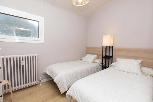 a bedroom with two beds and a window at Ático del Prado by BeValle in Sallent de Gállego