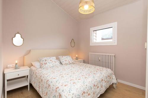 a white bedroom with a bed and a window at Ático del Prado by BeValle in Sallent de Gállego