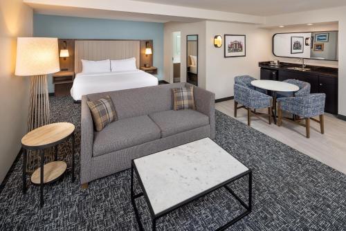 a hotel room with a bed and a couch and tables at DoubleTree by Hilton Johnson City in Johnson City