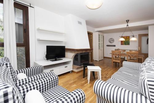 a living room with two couches and a tv at Casa Eguzkilore by BeValle in Escarrilla