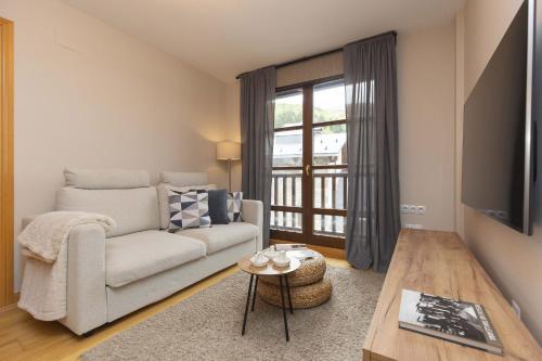 a living room with a couch and a table at Casa Lluna by BeValle in El Pueyo de Jaca