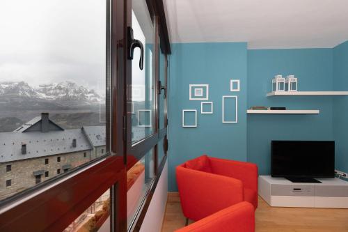 a living room with a red chair and a window at Narnia by BeValle in Panticosa