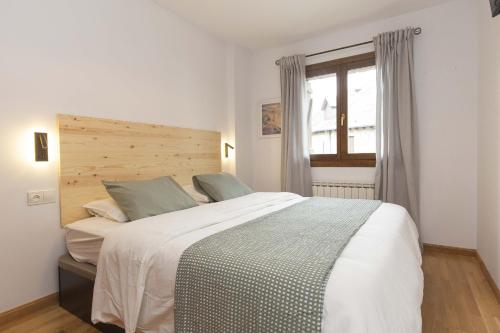 a bedroom with a large white bed with a window at Sueños de Telera by BeValle in El Pueyo de Jaca