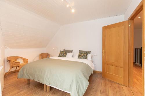 a bedroom with a large bed and a wooden door at Panorámica del Valle II by BeValle in Panticosa