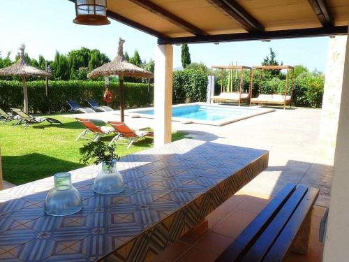 a patio with a table and chairs and a pool at Villa Son Fanals in Alcudia