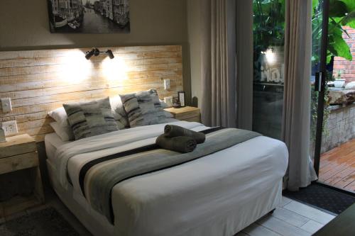 a bedroom with a bed with a teddy bear on it at Villa Mariss Guesthouse in Kraaifontein
