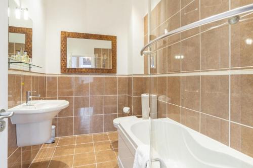 a bathroom with a sink and a tub and a toilet at The Tontine Hotel in Greenock