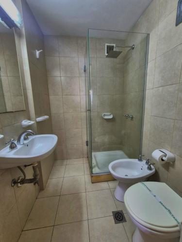a bathroom with a shower and a toilet and a sink at Hotel Juramento in Buenos Aires