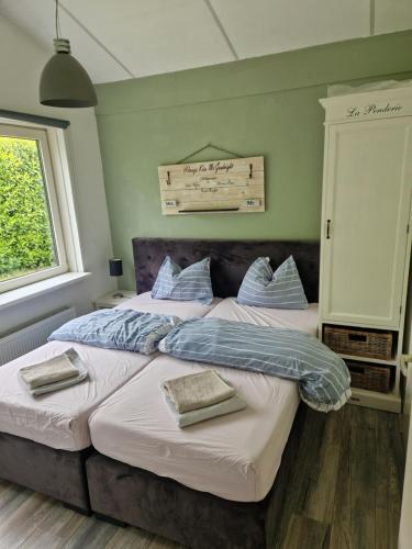 two beds in a bedroom with green walls at Huinerhofje 2 - Vrijstaand met grote omheinde tuin, rust, privacy en nabij bossen in Putten