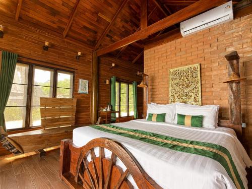 a bedroom with a large bed in a wooden room at Ting Rai Bay Resort in Ko Jum