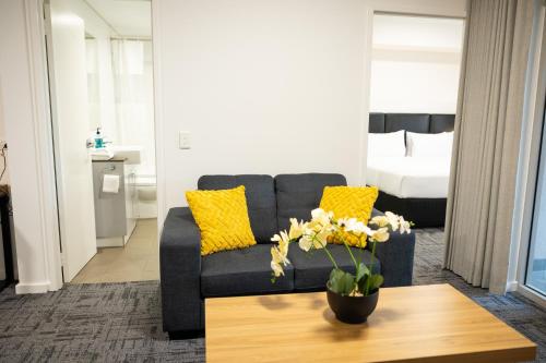 a living room with a couch and a table at Baileys Serviced Apartments in Perth