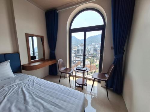 a hotel room with a bed and a large window at Galaxy Villa Tam Đảo in Tam Ðảo